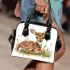 Cute little fawn sitting in the grass shoulder handbag