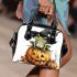 Frog wearing a black witch's hat sitting on top of halloween pumpkin shoulder handbag