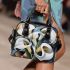 Painting of calla lilies in bold geometric shapes shoulder handbag