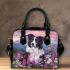 Black and white border collie sits in the foreground amidst blooming flowers shoulder handbag