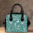 Butterflies and flowers scattered across shoulder handbag