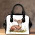 Cute baby deer sitting in the grass shoulder handbag