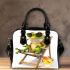 Cute cartoon frog sitting in the sun on an outdoor chair shoulder handbag