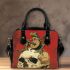 Green frog playing the banjo on top of human skull shoulder handbag