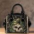 Green frog playing the banjo on top of human skull shoulder handbag