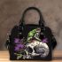 Green frog sitting on top of an skull with purple thistles growing shoulder handbag