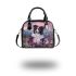 Black and white border collie sits in the foreground amidst blooming flowers shoulder handbag